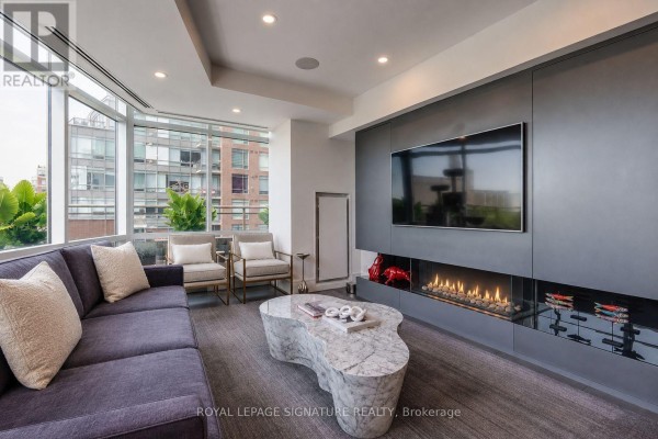 Living room fireplace with mounted television and modern seating. - 602e - 500 Queens Quay W, Toronto