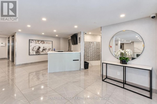 Building lobby with marble tile floors, mailboxes, and modern reception desk. - 603 - 10 Edgecliff Golfway, Toronto