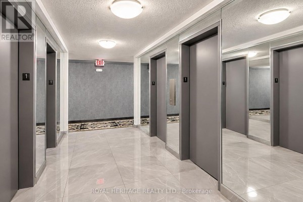 Elevator lobby with grey doors, mirrored walls, and patterned carpet runner. - 603 - 10 Edgecliff Golfway, Toronto