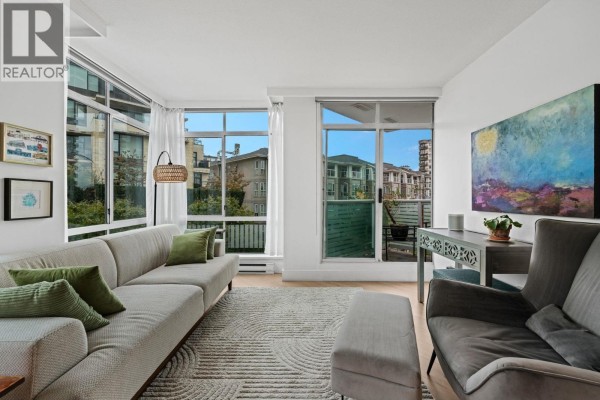 Apartment living space featuring a sofa, armchair, desk, and floor-to-ceiling windows. - 603 130 E 2nd Street, North Vancouver