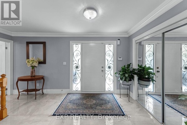 Interior entryway with a white front door, decorative glass panels, tiled floor, mirrored closet, and console table. - 6030 Doane Road, East Gwillimbury