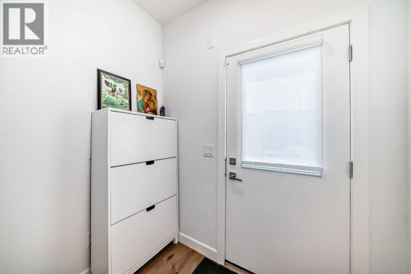 Bright entryway with storage cabinet and natural light from door - 604, 280 Chelsea Road, Chestermere