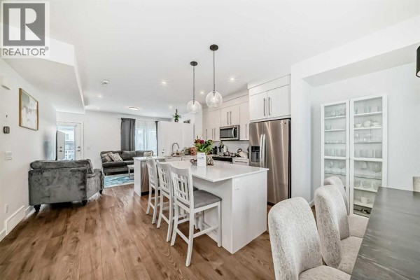 Open-concept kitchen and living area with modern appliances and seating - 604, 280 Chelsea Road, Chestermere