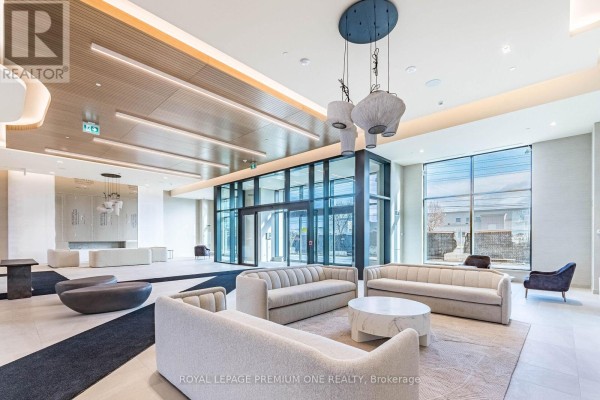 Bright condo lobby with large windows, light-colored sofas, and a marble coffee table. - 604 - 8960 Jane Street, Vaughan