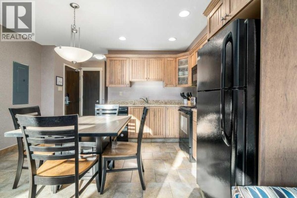 View of the kitchen and dining area with a large black refrigerator. - 604 & 605, 401 4 Street, Rural Cypress County