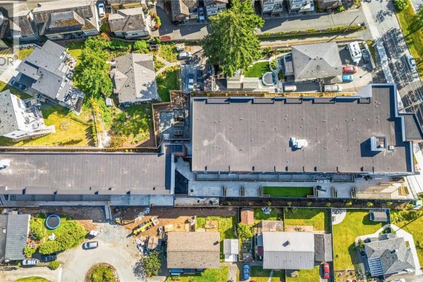 Side view of the apartment building showcasing balconies and architectural details. - 604 2629 Millstream Rd, Langford