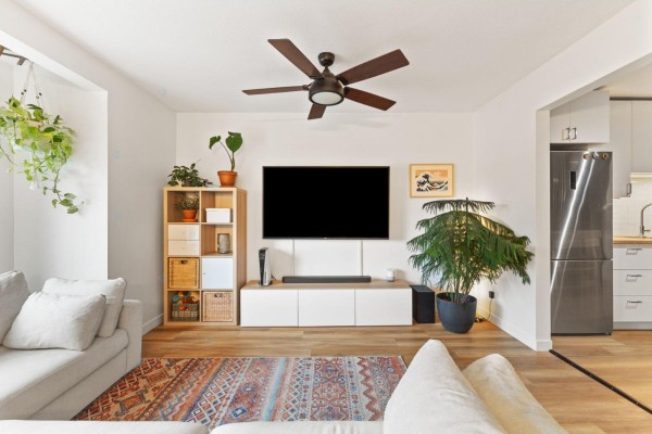 Living room with sectional couch, television, entertainment unit, and patterned rug. - 604 Boul. Des Hautes-plaines, Gatineau