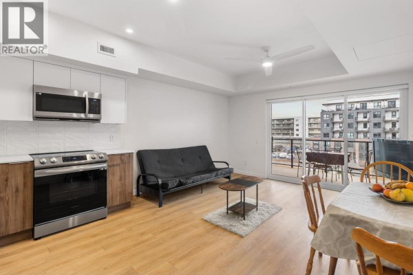 Open-concept living area with kitchen, dining table, and balcony access - 604 Cawston Avenue Unit# 404, Kelowna
