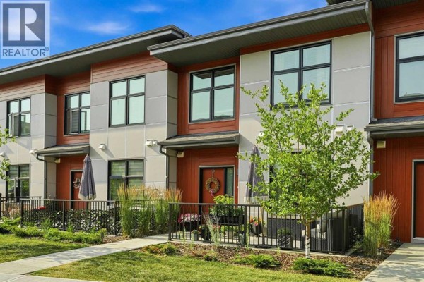 Front exterior of a multi-story townhouse complex with contemporary design elements. - 605, 400 Belmont Street Sw, Calgary