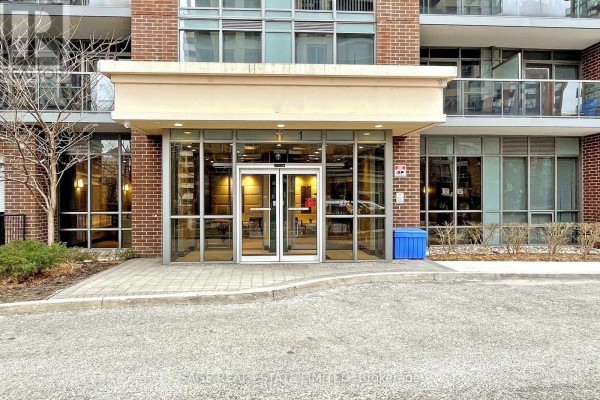 Front entrance of the apartment building with glass doors and brick detailing. - 605 - 1 Michael Power Place, Toronto