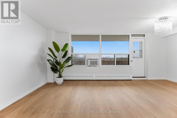Bright living area with potted plant and access to a balcony - 605 - 3120 Kirwin Avenue, Mississauga
