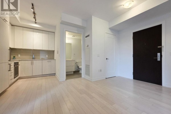 Kitchen area with modern cabinets, appliances, and a view of the bathroom door. - 605 - 330 Richmond Street W, Toronto