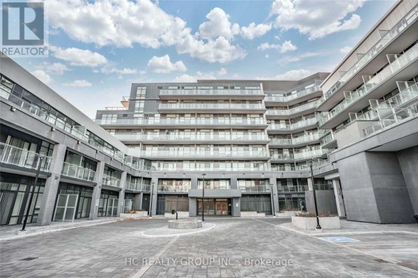 Courtyard view of a modern condominium building with grey brick and glass balconies. - 605 - 621 Sheppard Avenue E, Toronto