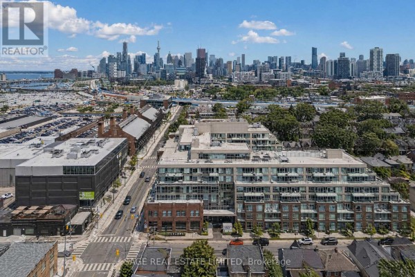 View of the Toronto skyline from a high vantage point with trees in the foreground. - 606 - 150 Logan Avenue, Toronto