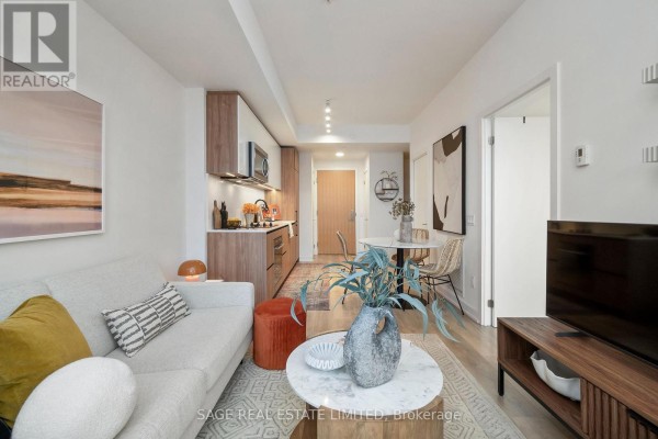 Modern kitchen with wood and white cabinetry, stainless steel appliances, and a marble countertop. - 606 - 150 Logan Avenue, Toronto