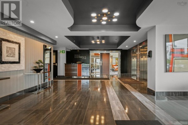 Spacious apartment building lobby with marble-patterned floors, modern light fixtures, and elevators. - 606 3471 Dutch Village Road, Halifax