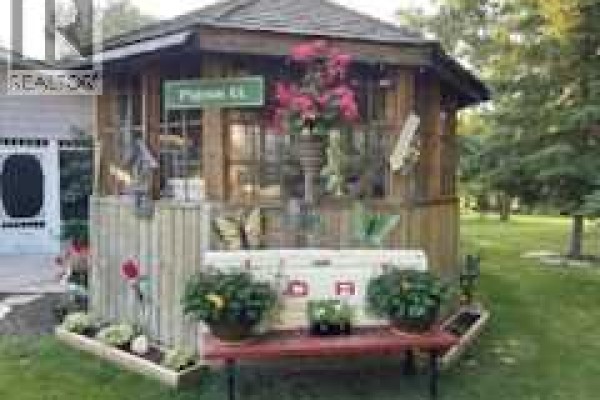 A wooden gazebo with a sign that reads "Pigeon Bl" and floral decorations. - 606 Pigeon Close, Pelican Point