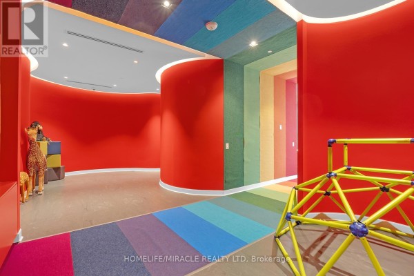 Colorful children's play area with red walls, rainbow carpet, and climbing structure. - 607 - 20 Tubman Avenue, Toronto