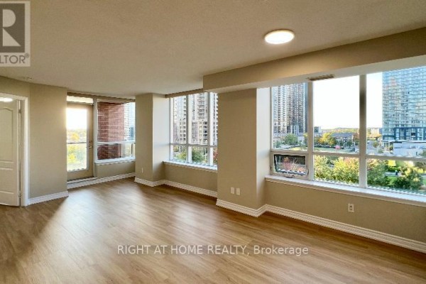 Spacious, bright living room with large windows, light wood floors, and city views. - 607 - 4090 Living Arts Drive, Mississauga