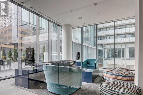 A stylish communal lounge with floor-to-ceiling windows, modern furniture, and seating areas. - 607 - 42 Charles Street, Toronto