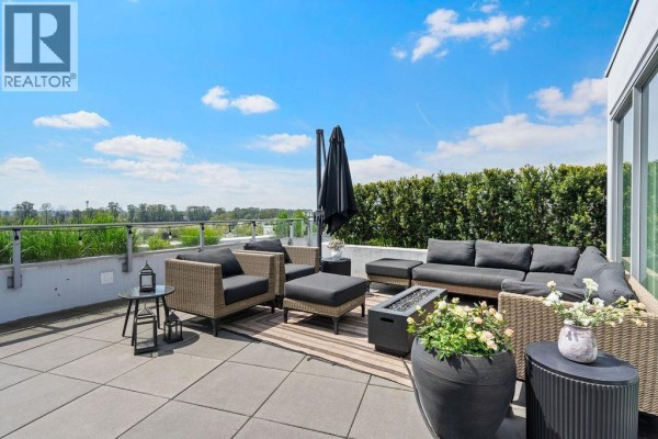Rooftop patio with outdoor furniture, dining table, and surrounding buildings. - 607 3438 Sawmill Crescent, Vancouver