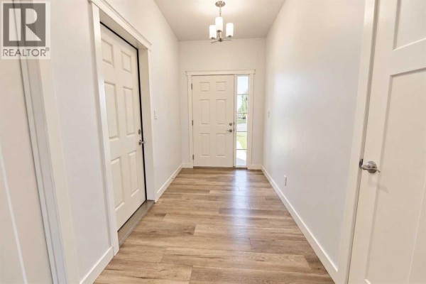 Interior entryway with white walls, wood-look flooring, and two doors. - 608 10 Avenue W, Barnwell