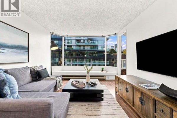 Dining area with wooden table and chairs, adjacent to living room and city view. - 608 1330 Hornby Street, Vancouver
