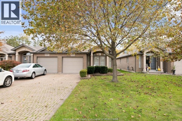Street view of beige brick townhouses on a tree-lined street with autumn foliage. - 6085 Natalie Court, Lasalle