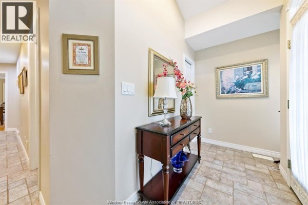 Interior entryway with beige tiled floors, a console table, mirror, and framed art. - 6085 Natalie Court, Lasalle