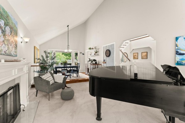 Entrance foyer with white front doors, wood floors, white banister staircase, and a dark wood console table. - 6089 185 Street, Surrey