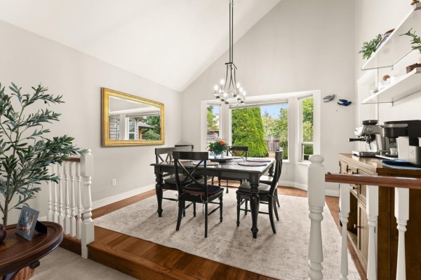 Interior foyer view with a light beige staircase, wood floors, console table, and entrance to living and dining rooms. - 6089 185 Street, Surrey