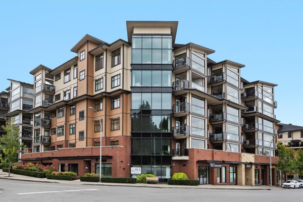 Exterior of a multi-story apartment building with balconies and brick and wood siding. - 609 20328 86 Avenue, Langley