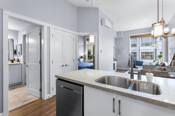 View from the kitchen into a hallway leading to a bathroom and bedroom. - 609 20328 86 Avenue, Langley