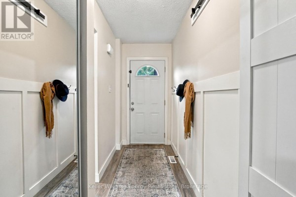 Interior hallway with white paneling, a large mirror, and a white front door with a glass insert. - 61 - 155 Glovers Road, Oshawa