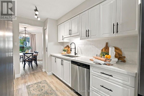 Kitchen with white cabinets, quartz countertops, subway tile backsplash, and stainless steel appliances. - 61 - 155 Glovers Road, Oshawa