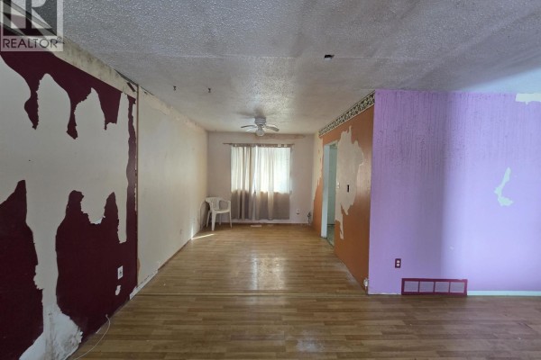 Close-up of the purple and orange walls in the living room, with a view into the kitchen. - 61 Chapman Street, Granisle