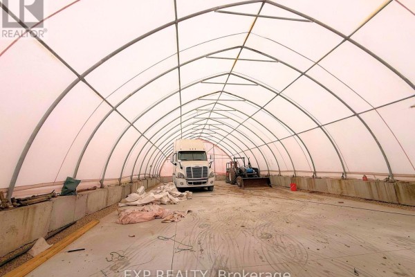 Interior view of a large arched white fabric building with a semi-truck and tractor inside. - 61 Durrow Street, London South