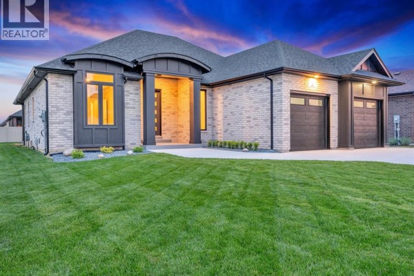 Aerial view of a modern beige brick house with two garage doors and a gravel driveway. - 61 Hilton Court, Amherstburg