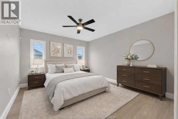 Bedroom with king bed, dresser, and circular mirror - 61 Hilton Court Amherstburg
