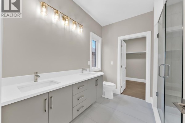 Modern bathroom with double vanity, glass shower, and walk-in closet - 61 Hilton Court Amherstburg
