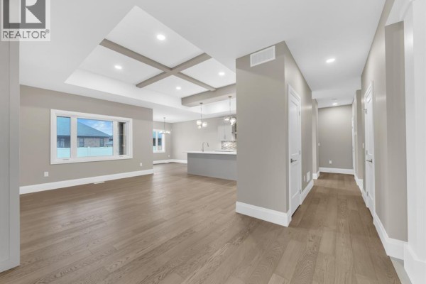 Open concept living room with coffered ceiling, hardwood floors, kitchen island - 61 Hilton Court Amherstburg