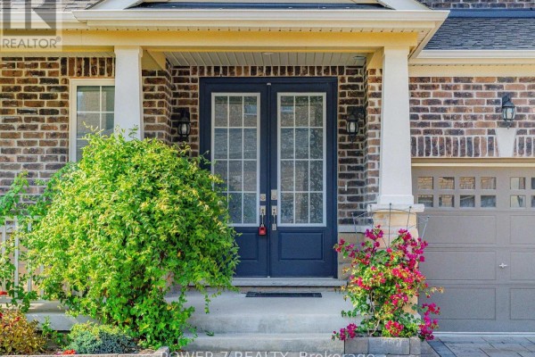 Close-up of the front entrance with double doors, sidelights, and decorative plants. - 61 Match Point Court, Aurora