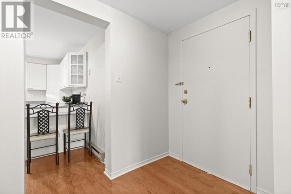 Interior view of apartment entryway and adjacent kitchen with white cabinets. - 61 Nelsons Landing Boulevard, Bedford