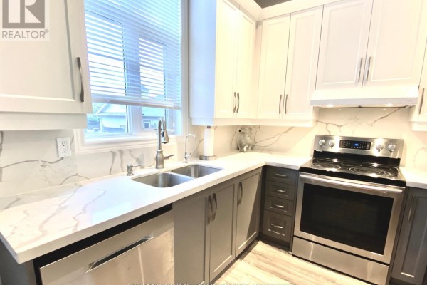 Kitchen corner with double sink, stainless steel stove, and white blinds on window. - 61 Walkerville Road, Markham
