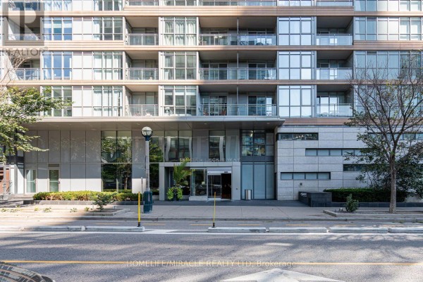 Close-up of the modern glass and stone facade and main entrance of an apartment building. - 610 - 151 Dan Leckie Way, Toronto