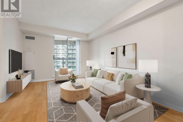 Living room with a sectional sofa, decorative pillows, a round coffee table, and a wall-mounted TV. - 610 - 23 Lorraine Drive, Toronto