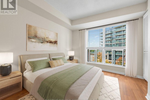 Bedroom with a king-size bed, green bedding, nightstands, and a large window with a city view. - 610 - 23 Lorraine Drive, Toronto