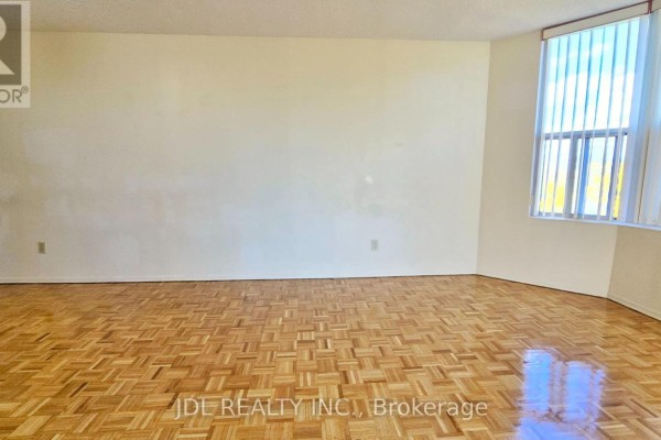 Empty living room with parquet flooring and large bay windows. - 610 - 5795 Yonge Street, Toronto