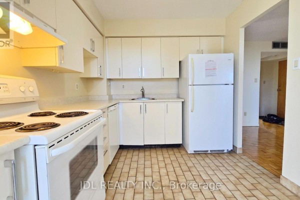 Kitchen with white cabinets, white appliances, sink, and view of the hallway. - 610 - 5795 Yonge Street, Toronto