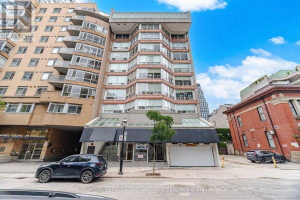 Front facade of the 82 Lombard Street apartment building with cars parked on the street. - 610 - 82 Lombard Street, Toronto